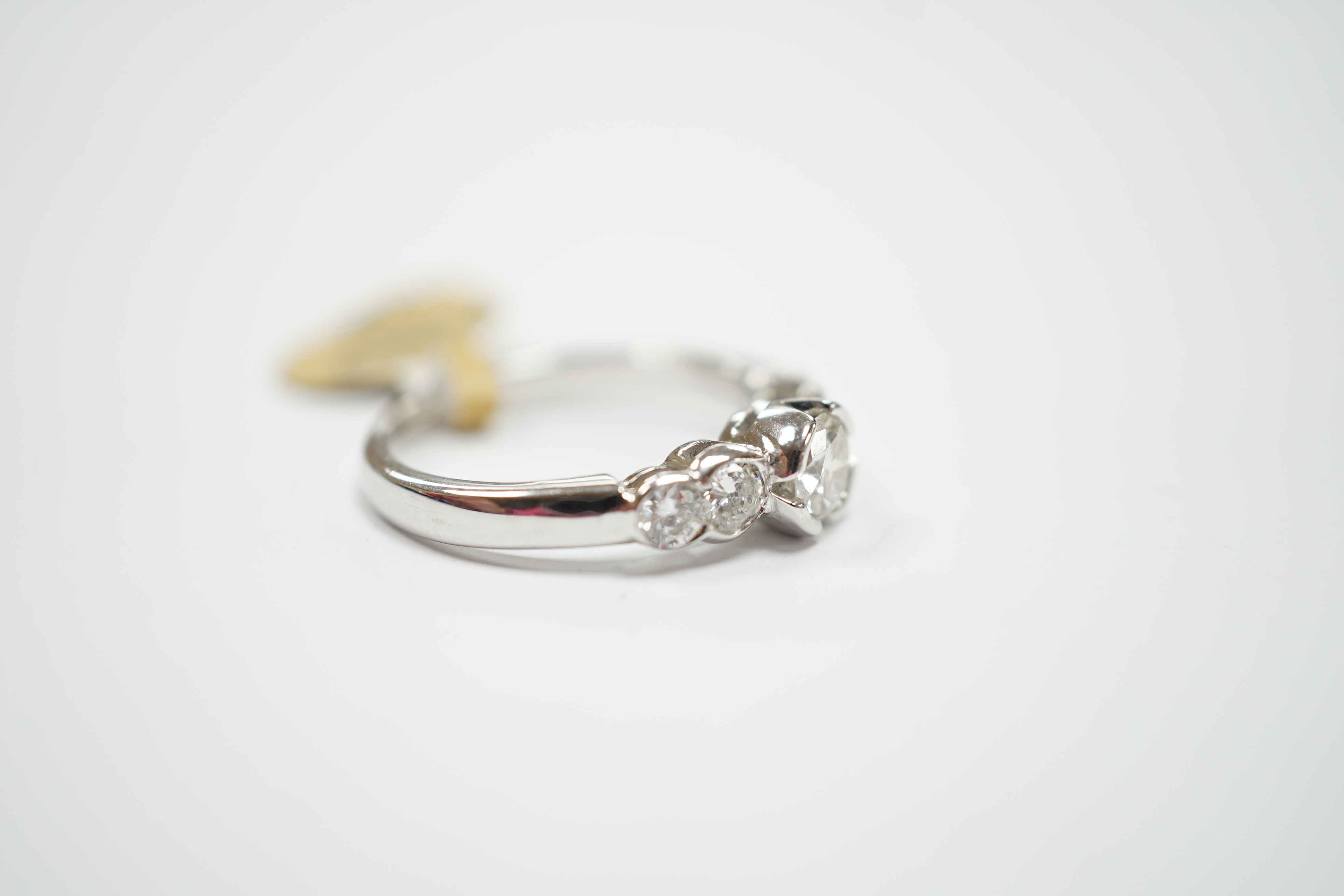 A white metal and five stone diamond set half hoop ring, total diamond weight 0.79ct, size M, gross weight 4.2 grams.